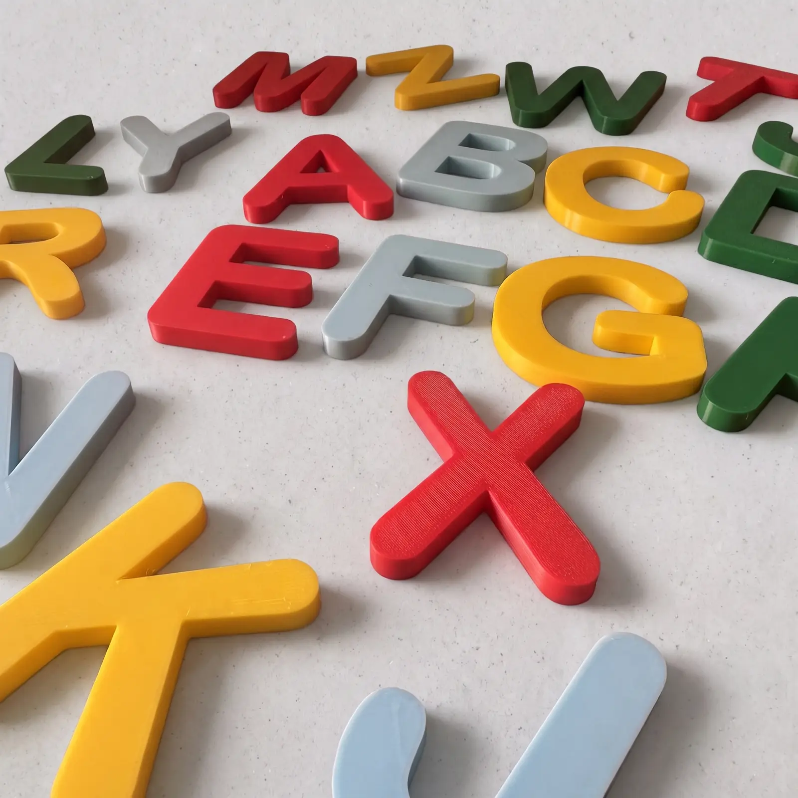 Primer plano de letras imantadas de colores: A, B, C, E, F y G