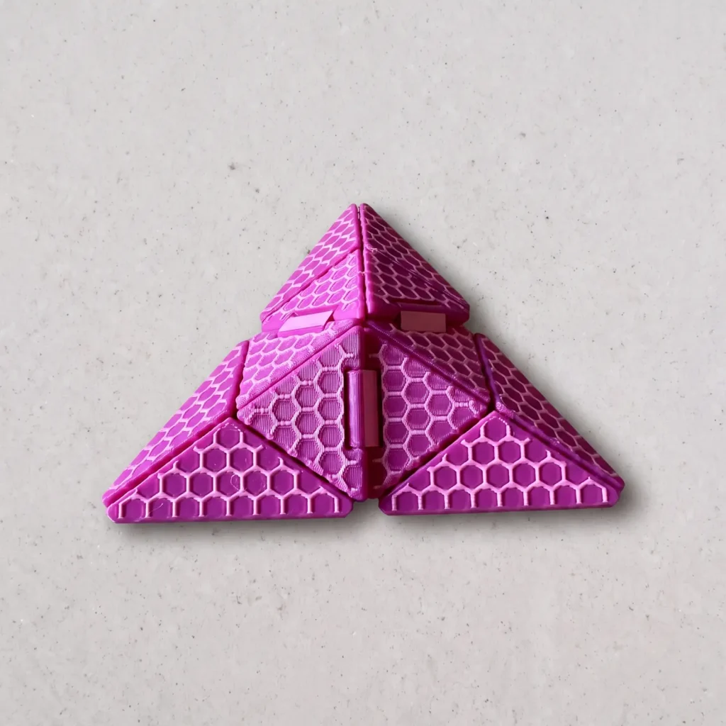 Origami infinito impreso en 3D en fucsia, cerrado como una pirámide, con textura de panal