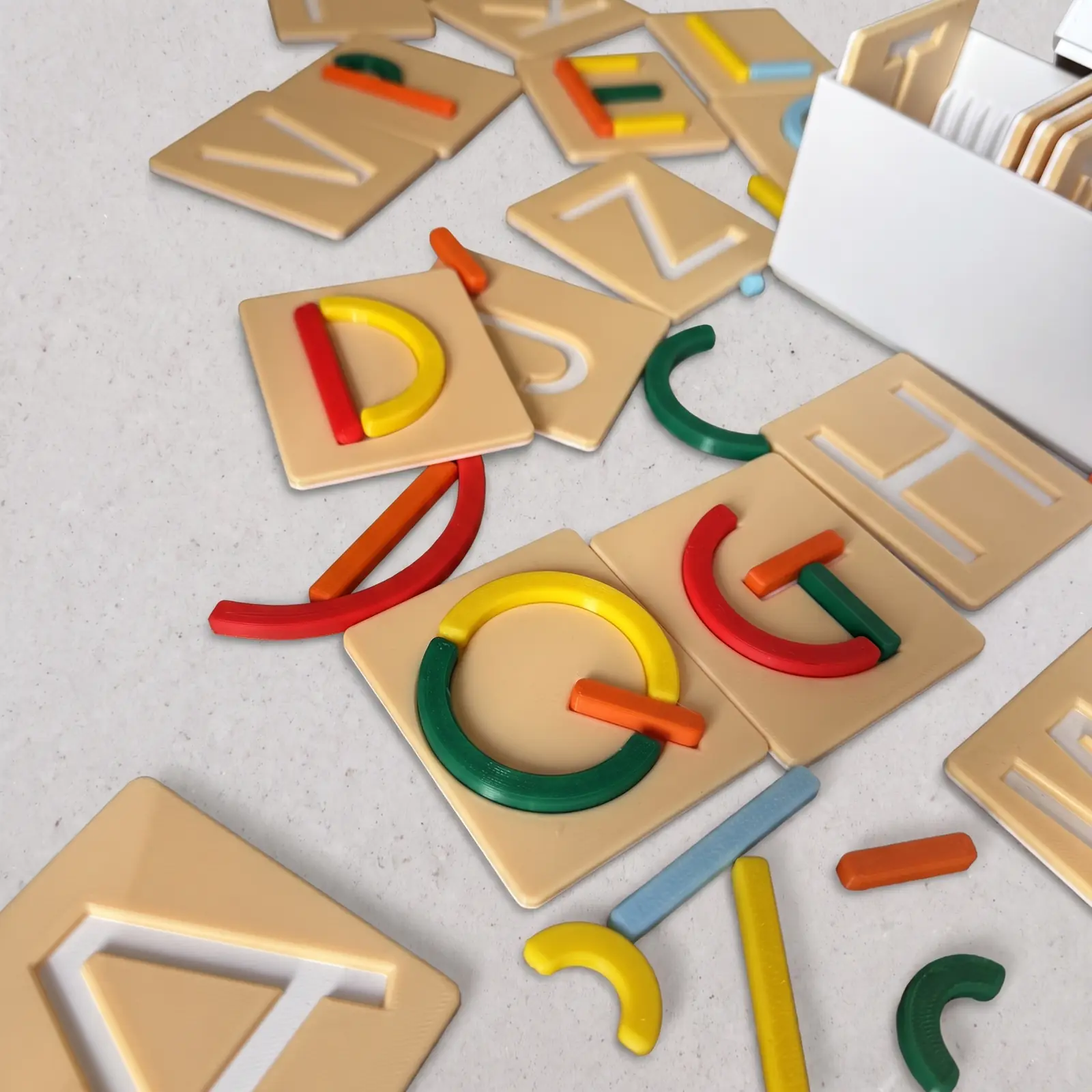 Tarjetas con las letras D, G y C completadas con trazos rojos, verdes y naranjas