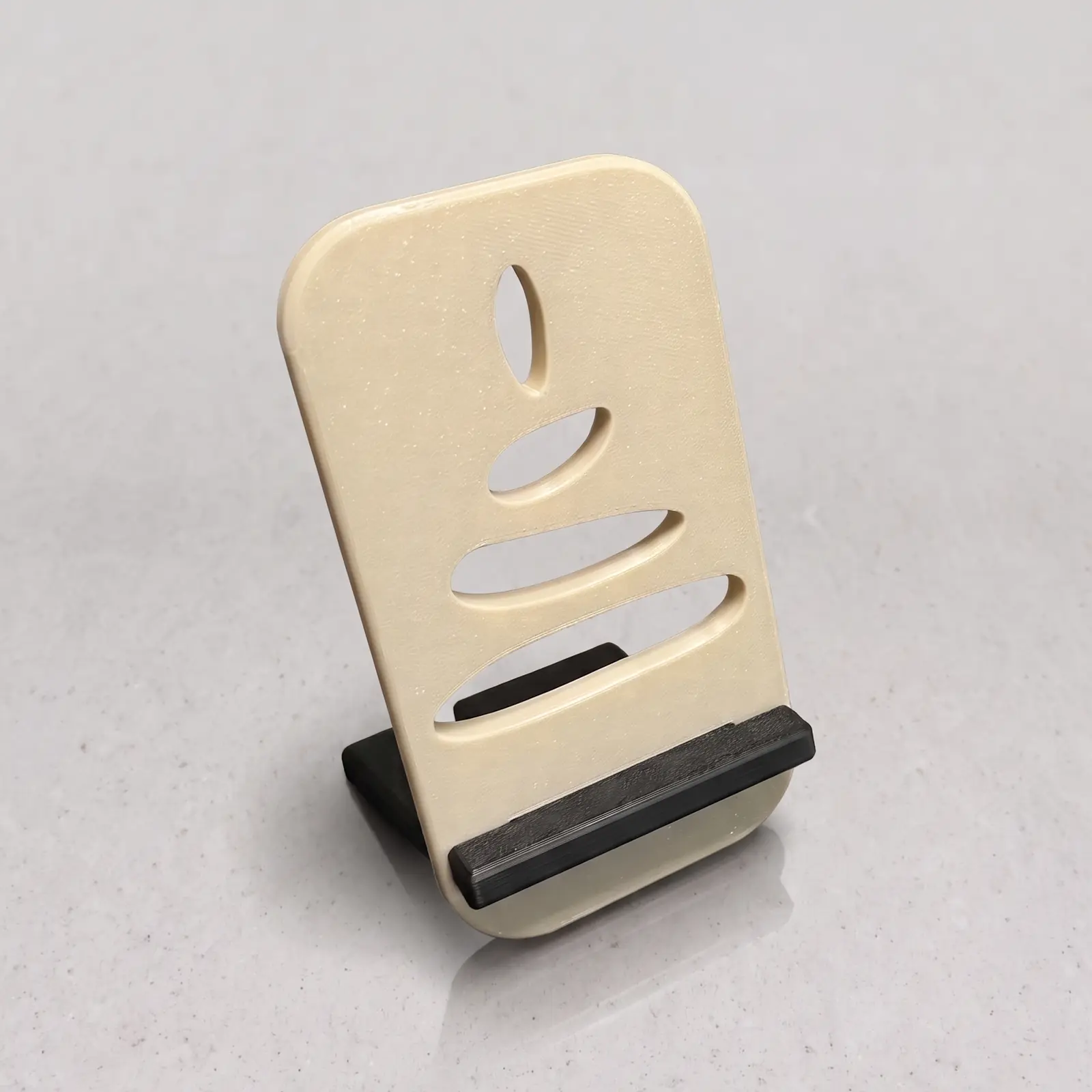 Porta celular beige con piedras apiladas visto en ángulo, con el soporte negro