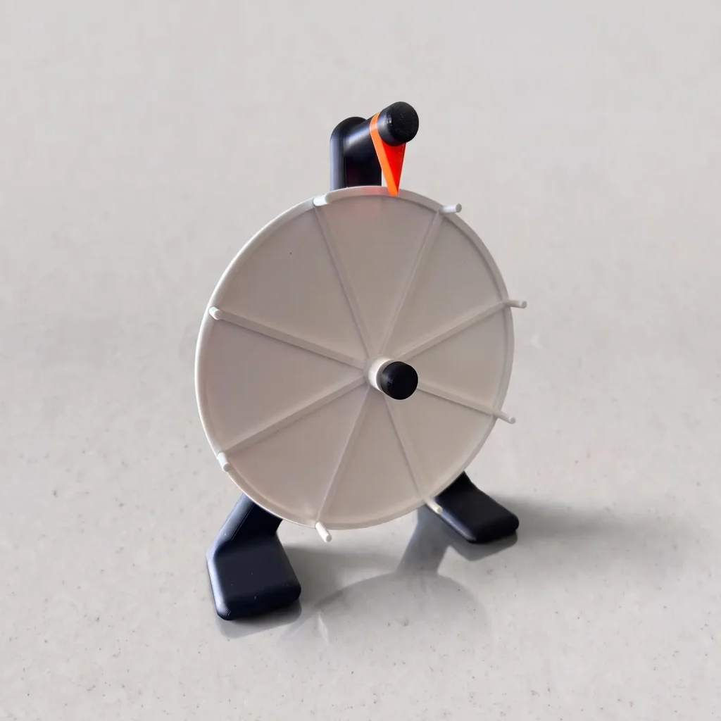 Ruleta de 8 segmentos impresa en 3D, rueda blanca con base negra e indicador naranja, vista de frente