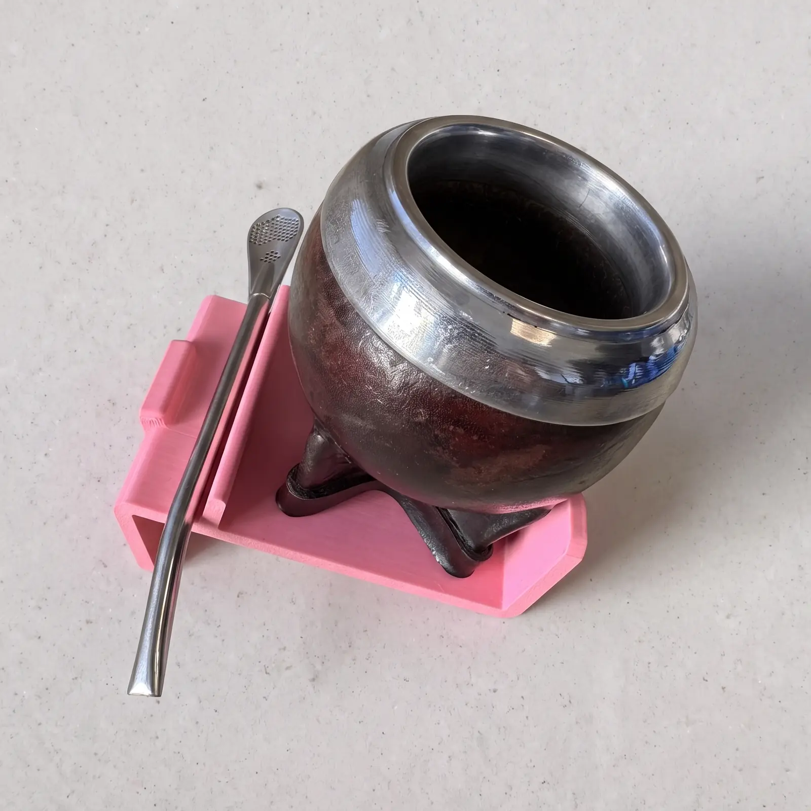 Mate con bombilla apoyado inclinado en el soporte montañita rosa